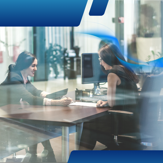 Women in the office consulting over work